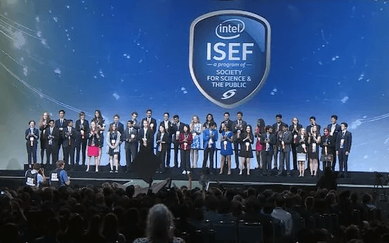 A group on a stage beneath the Intel ISEF logo, with an audience in the foreground